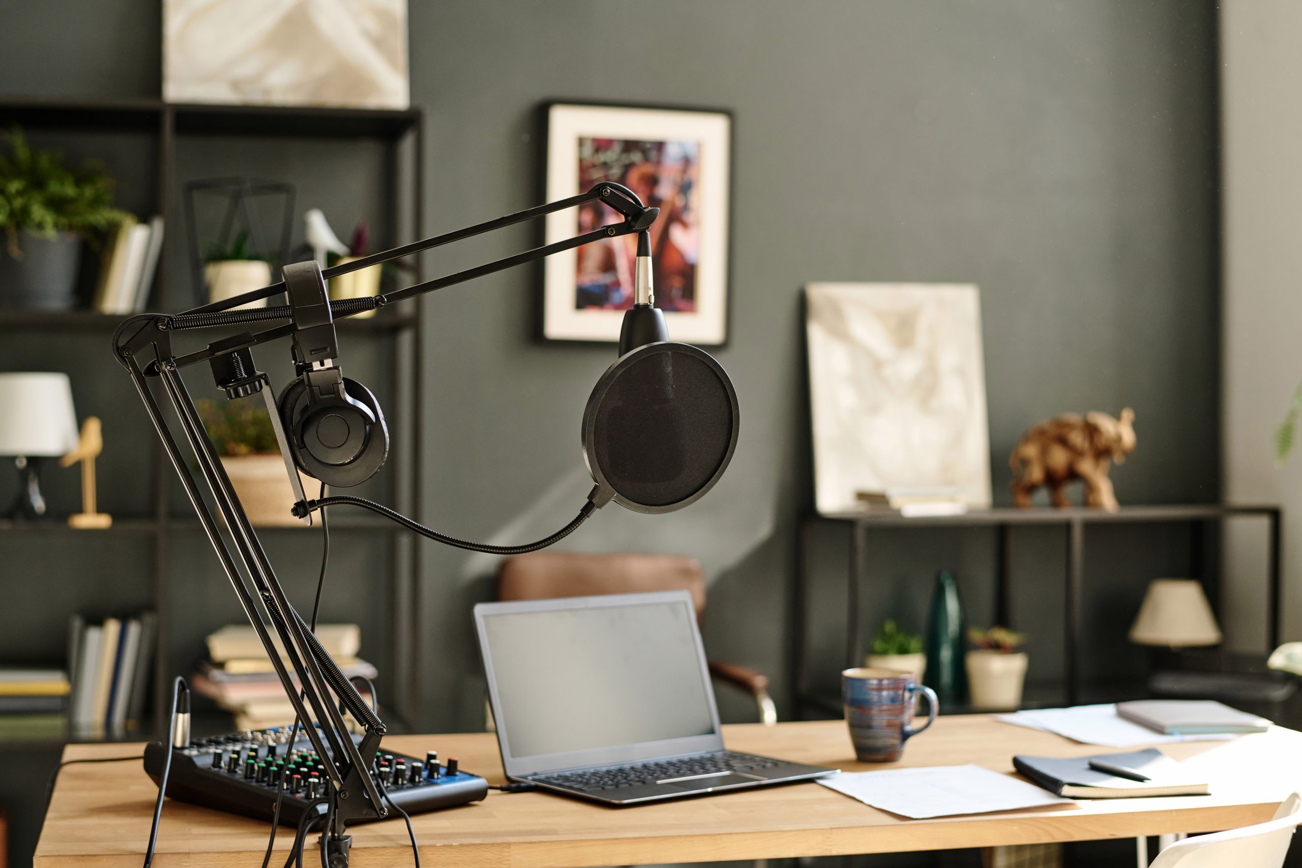 Laptop surrounded by sound recording equipment standing on workplace of modern blogger, radio presenter or deejay in studio